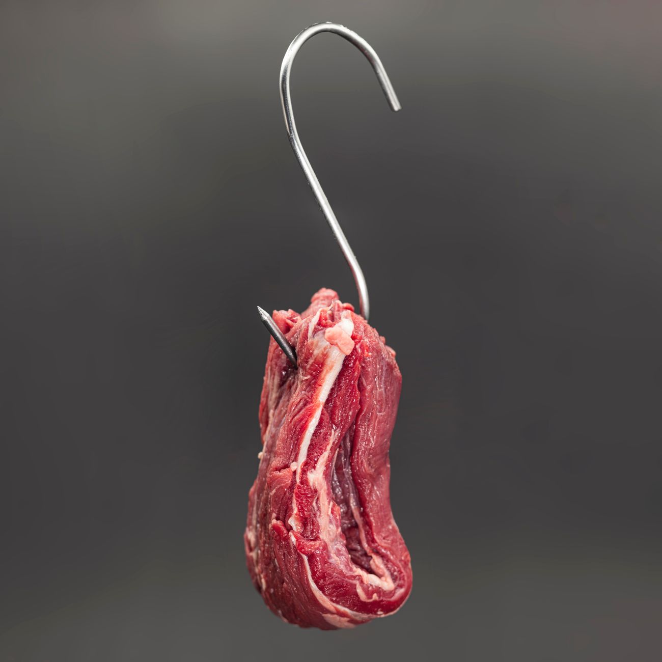 A carefully trimmed cut of beef hanging in the butcher's shop