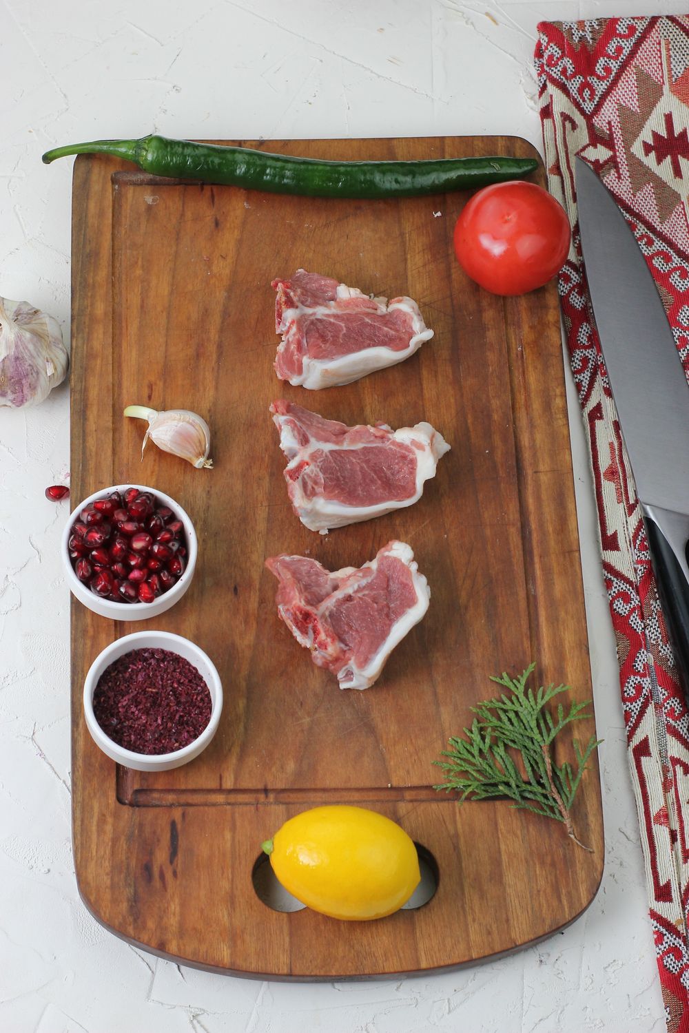 Fresh lamb chops arranged on a wooden serving board